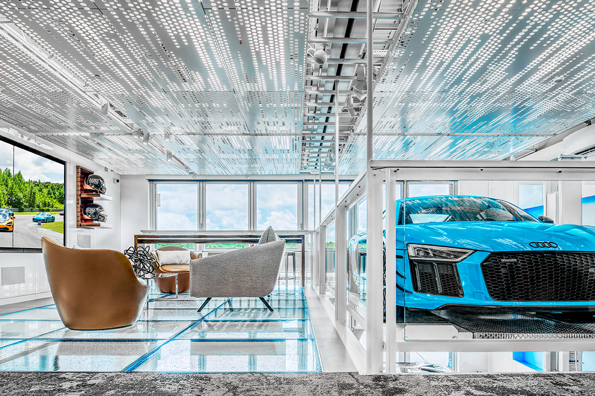 stunning modern home with a sitting area on the left and an electric-blue luxury car on the right, visible through glass panels.