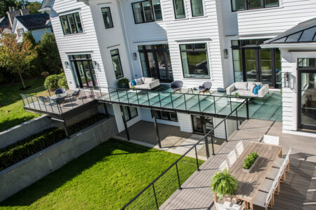 A stunning glass deck on the outside of a modern home with glass skylight features