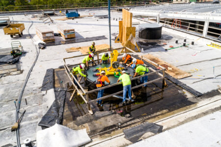 A team of construction workers from Glass Flooring Systems installing a skylight at Post HTX