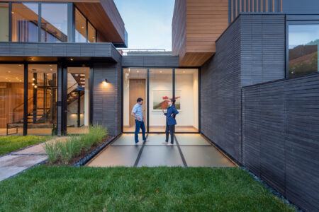 Two people talking on a glass floor inset in a lush garden pathway.