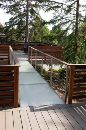 A walkway with a glass railing, blending seamlessly with a serene outdoor setting.