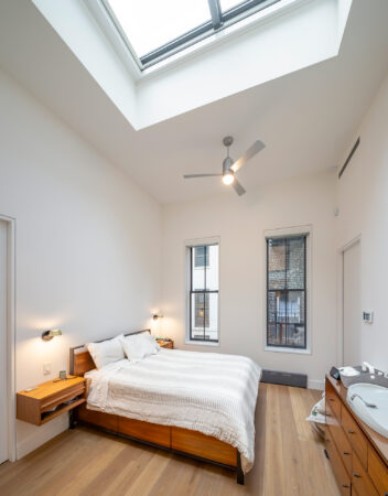 A bedroom with a large skylight window installed in the ceiling, allowing for natural lighting.