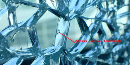 Nickel sulfide inclusion within a shattered glass panel highlighted.