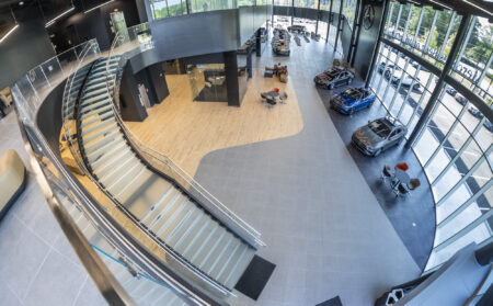 Overhead perspective of the glass staircase in Mercedes-Benz showroom, with curved lines and a seamless design that complements the open layout.