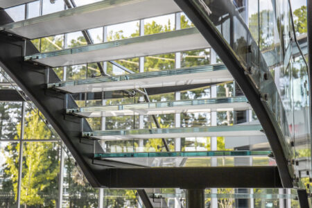 Close-up of the glass treads on the Mercedes-Benz showroom staircase, highlighting the tempered glass and secure structural support.