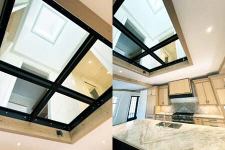 A stunning kitchen skylight with glass panels framed in black, offering a clear view of the floors above and natural light below.