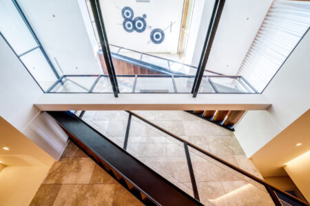 Modern architectural staircase with sleek glass panels providing an open and airy feel, showcasing a blend of functionality and style.