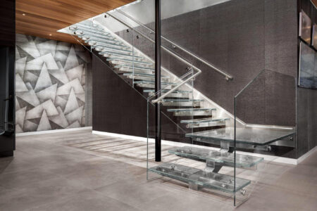 This contemporary indoor glass staircase features sleek lines and transparency, creating a bold, sophisticated focal point.