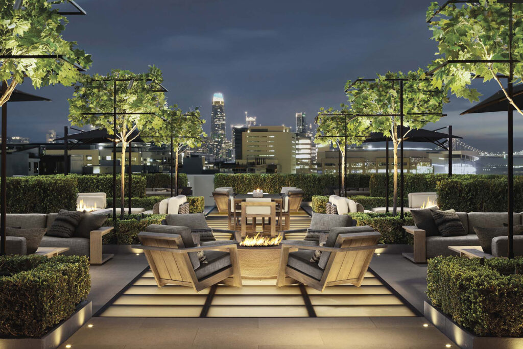 A rooftop terrace features illuminated glass flooring, offering a sustainable architectural solution and an elegant cityscape view.