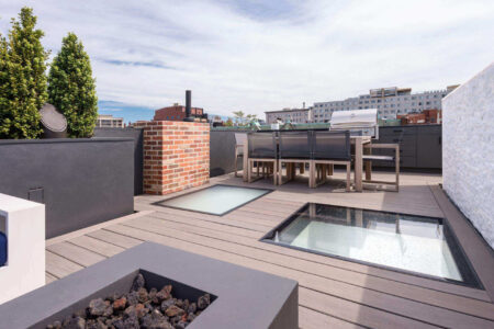 Rooftop deck featuring two large walkable glass panels, providing natural light to the interior below while enhancing the outdoor entertainment space.