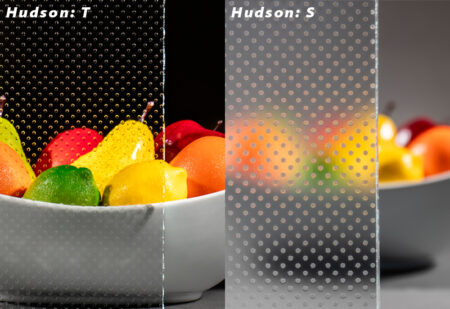 Side-by-side comparison of Hudson T and Hudson S glass textures, showing varying levels of clarity and privacy with a vibrant fruit bowl behind the glass.