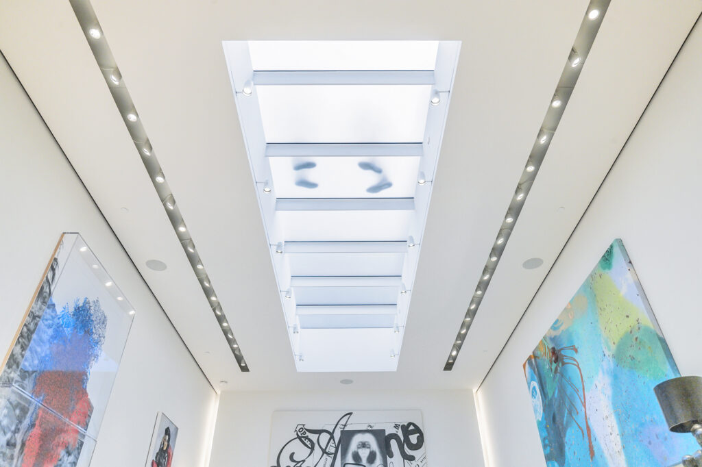 Frosted glass floor panels on a ceiling allow natural light into the room below, enhancing brightness and modern architectural appeal.