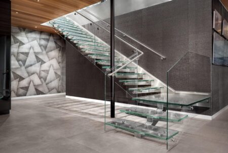 A modern staircase made entirely of textured glass treads and glass side panels in a high-end residential space.