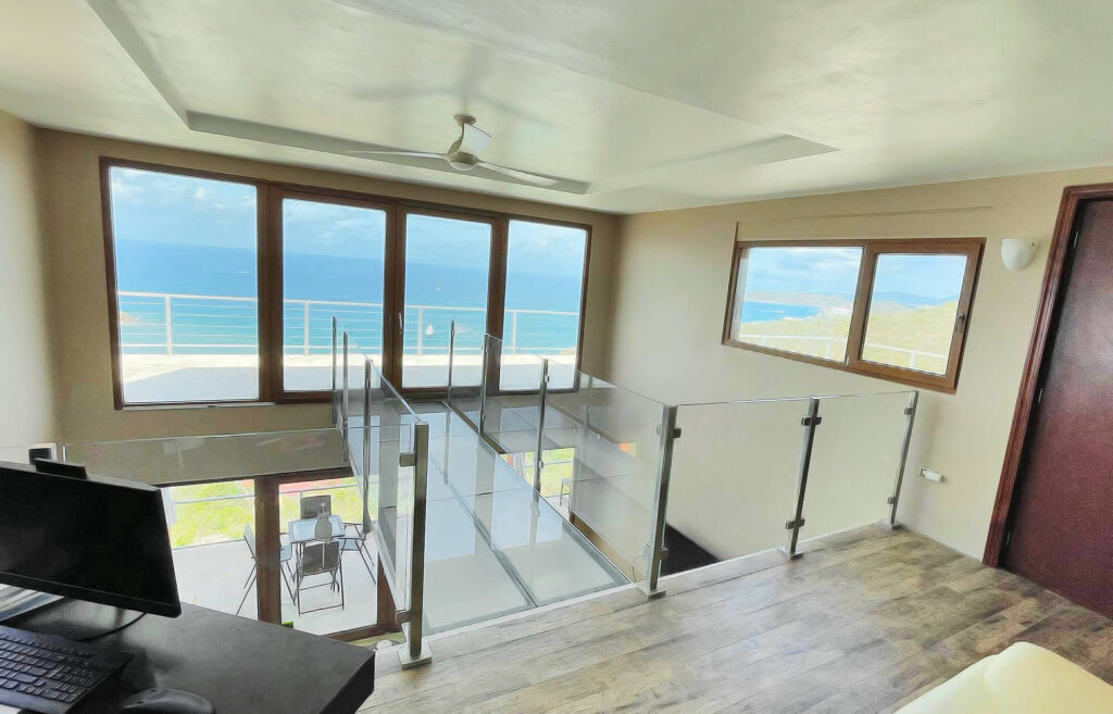 A residential home with a glass bridge and glass side panels.