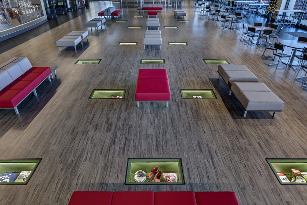 Spacious public seating area with embedded glass display panels on the floor.
