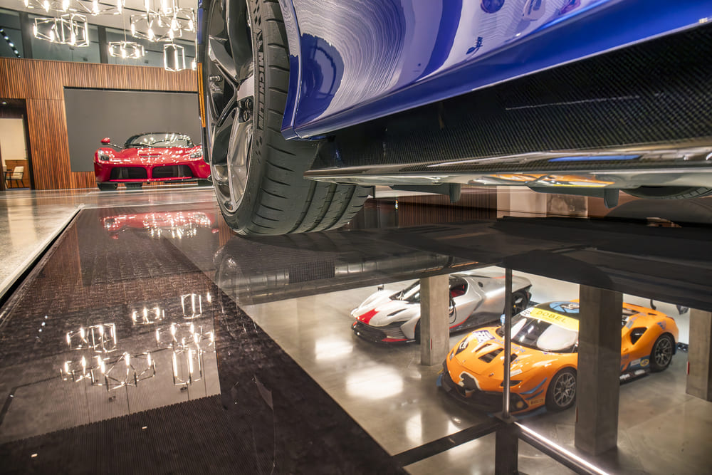 A showroom of luxury cars with floorings made of glass.