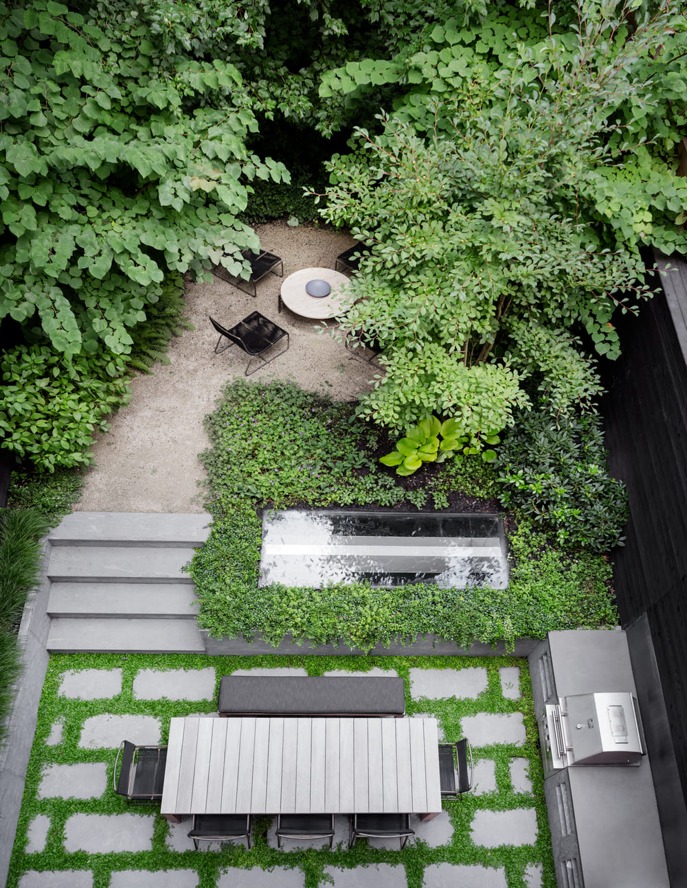 Aerial view of a small backyard garden with a rectangular skylight installation.