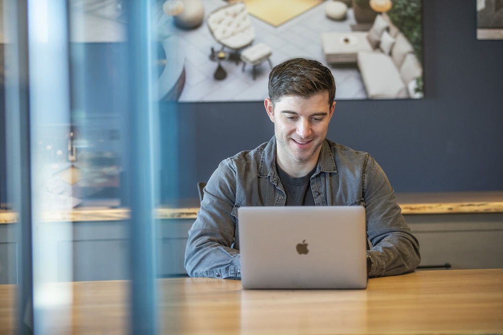A guy in the office, working on his laptop.