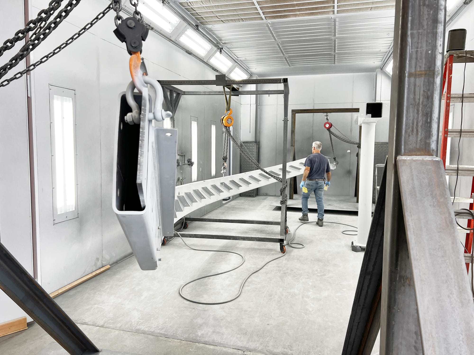 Technicians assembling glass panels in a modern construction facility using precision tools.