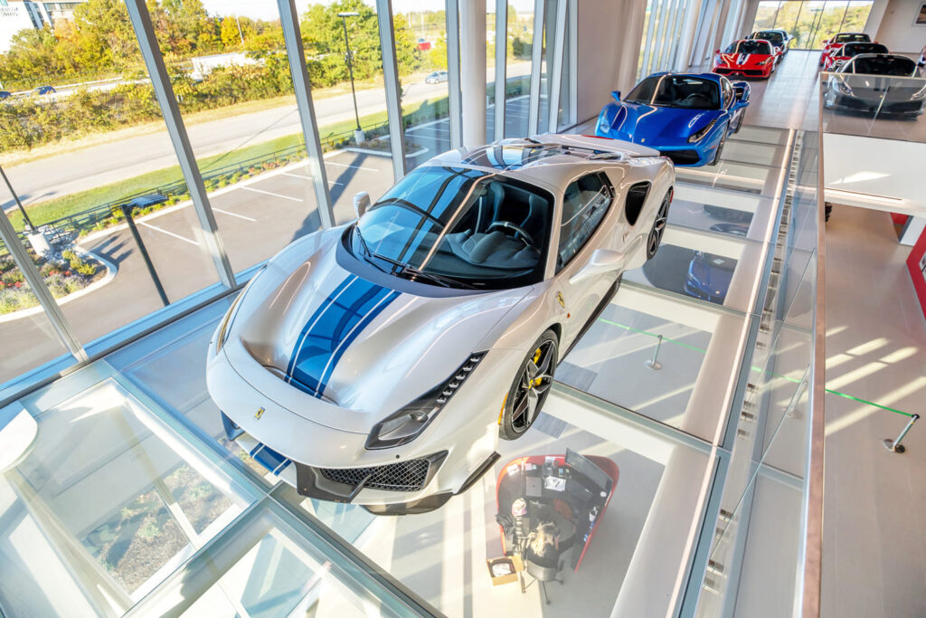 A luxury car dealership's showroom, showcasing their cars on top glass panels.