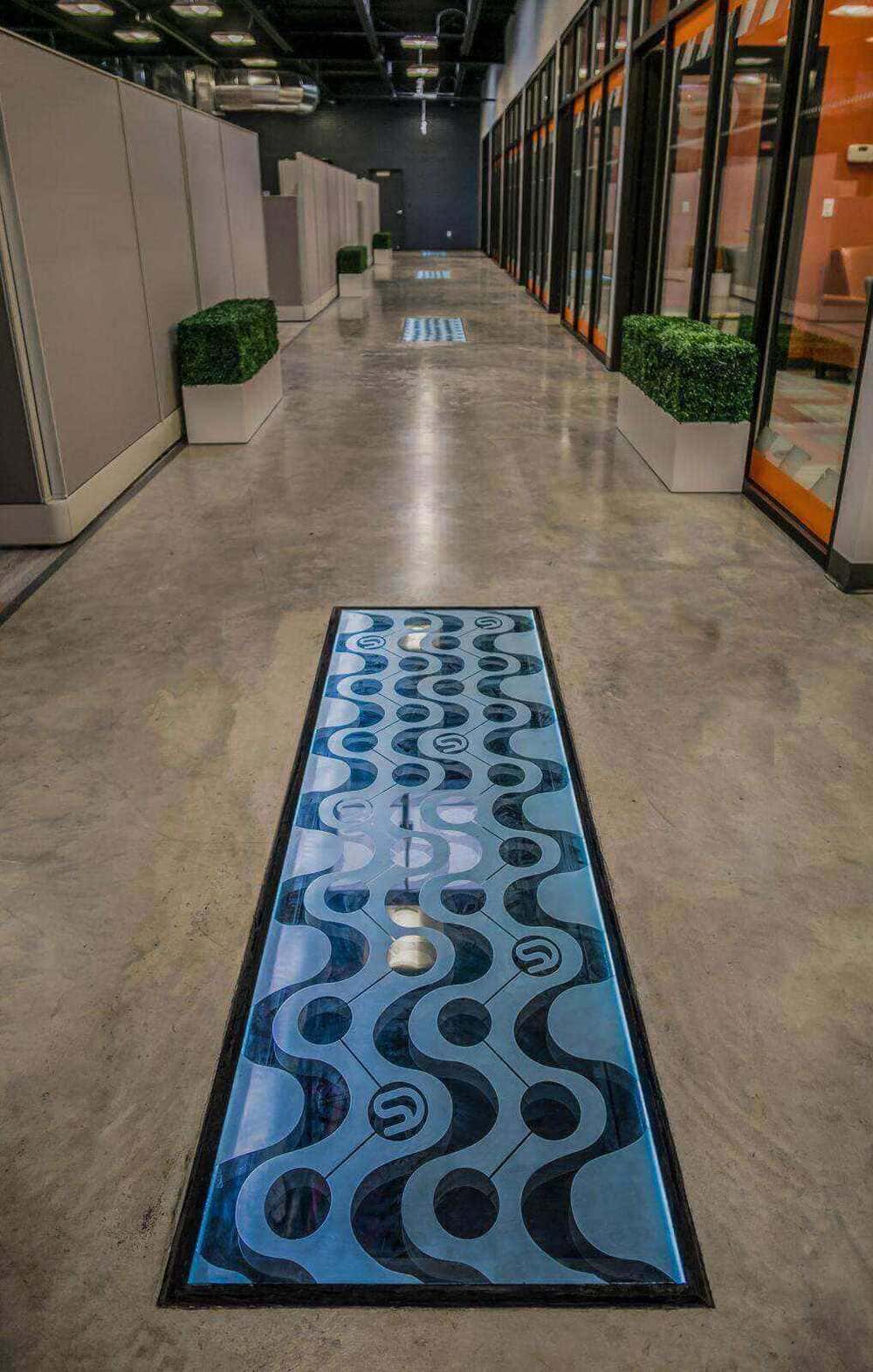 An office hallway where blue glass floor panels are installed.