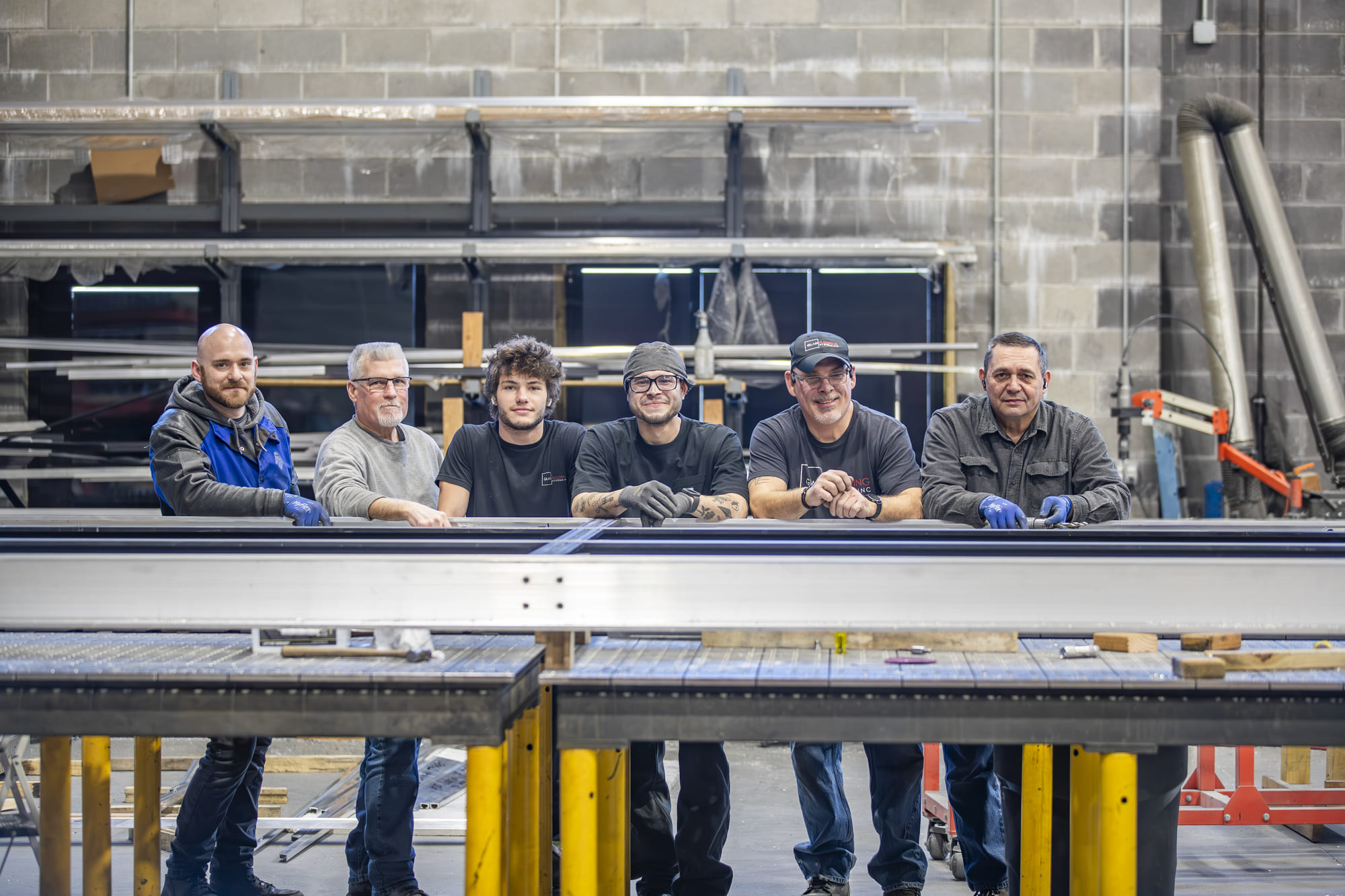 Team of factory workers overseeing the production process of custom glass materials.