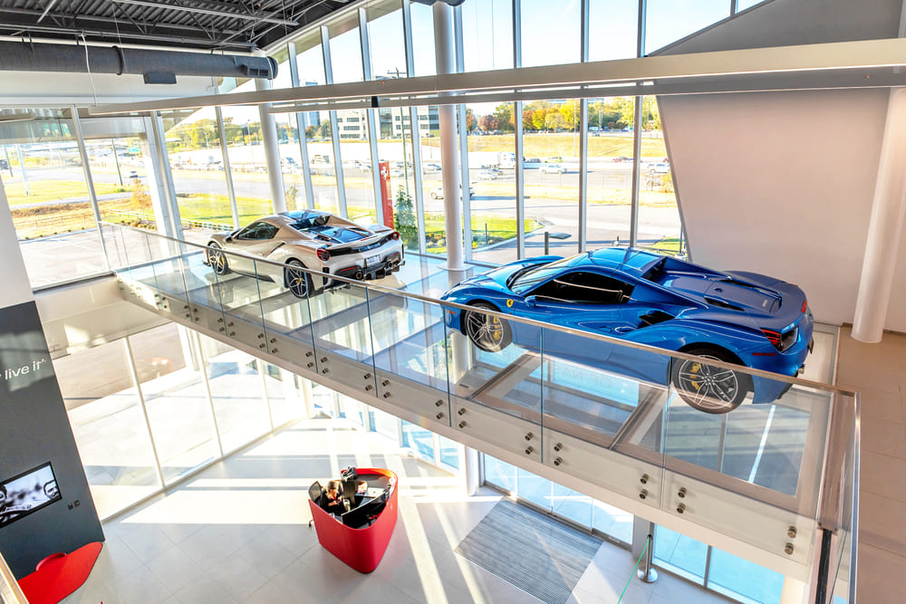 Glass garage floor with cars and natural light flooding through large windows.