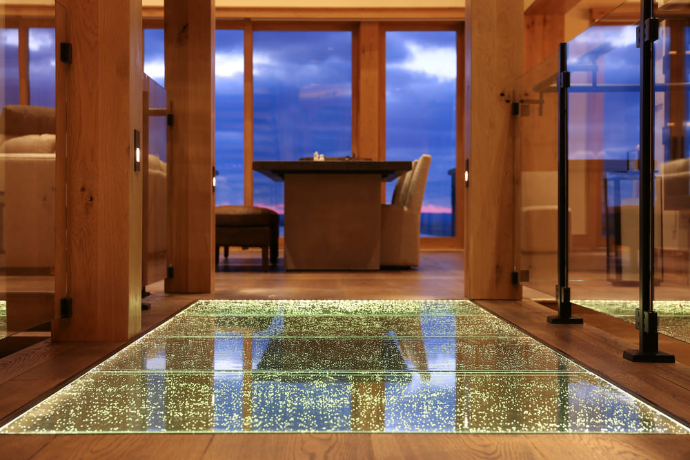 Dining area with a decorative glass floor section illuminated from below.
