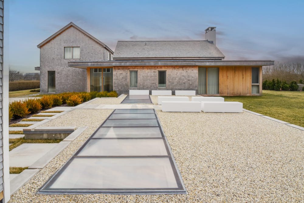 Modern home exterior with long rectangular skylights built into a minimalist walkway.