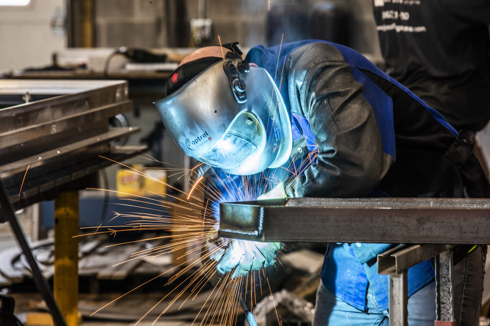 A person wearing a protective gear while building a metal frame.