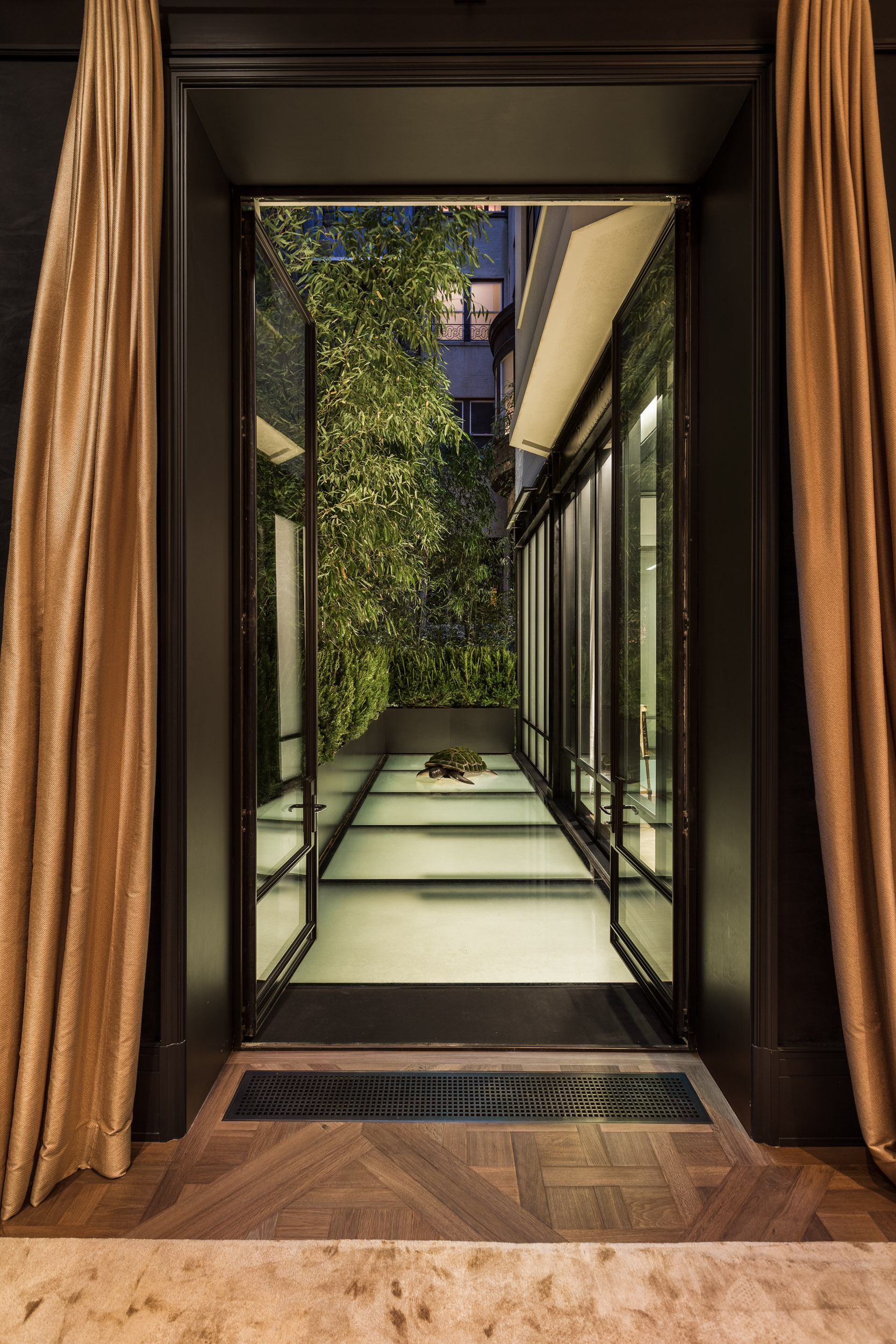 Narrow corridor with a long glass skylight roof letting in natural light.