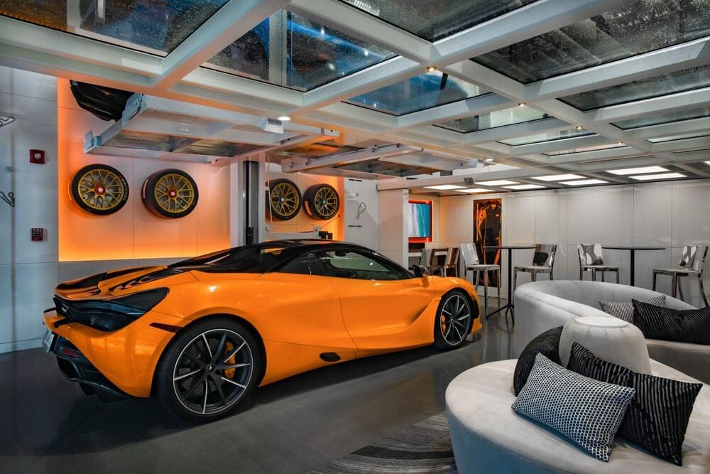 Curved architectural glass installed above a sports car inside a modern showroom.