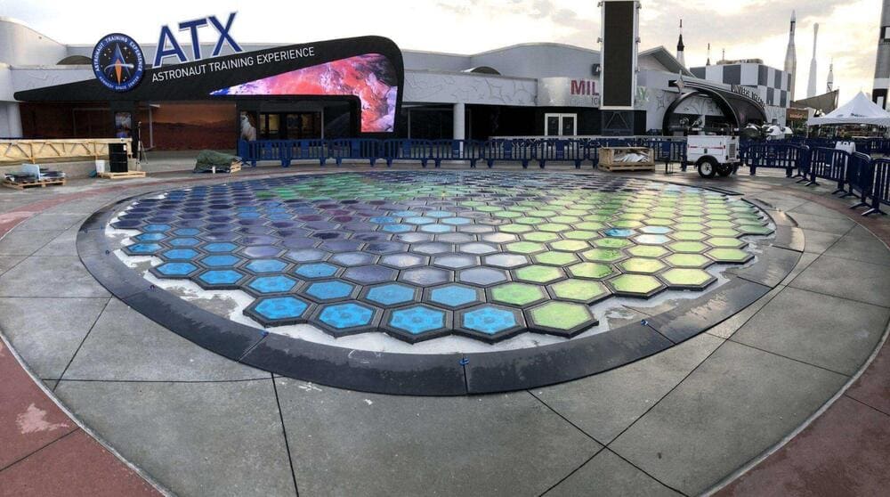Interior lounge area with a large geometric skylight illuminating minimalist furnishings.