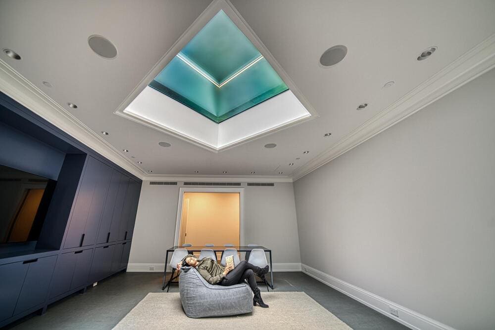 Interior of a modern space featuring a circular skylight and soft ambient lighting.