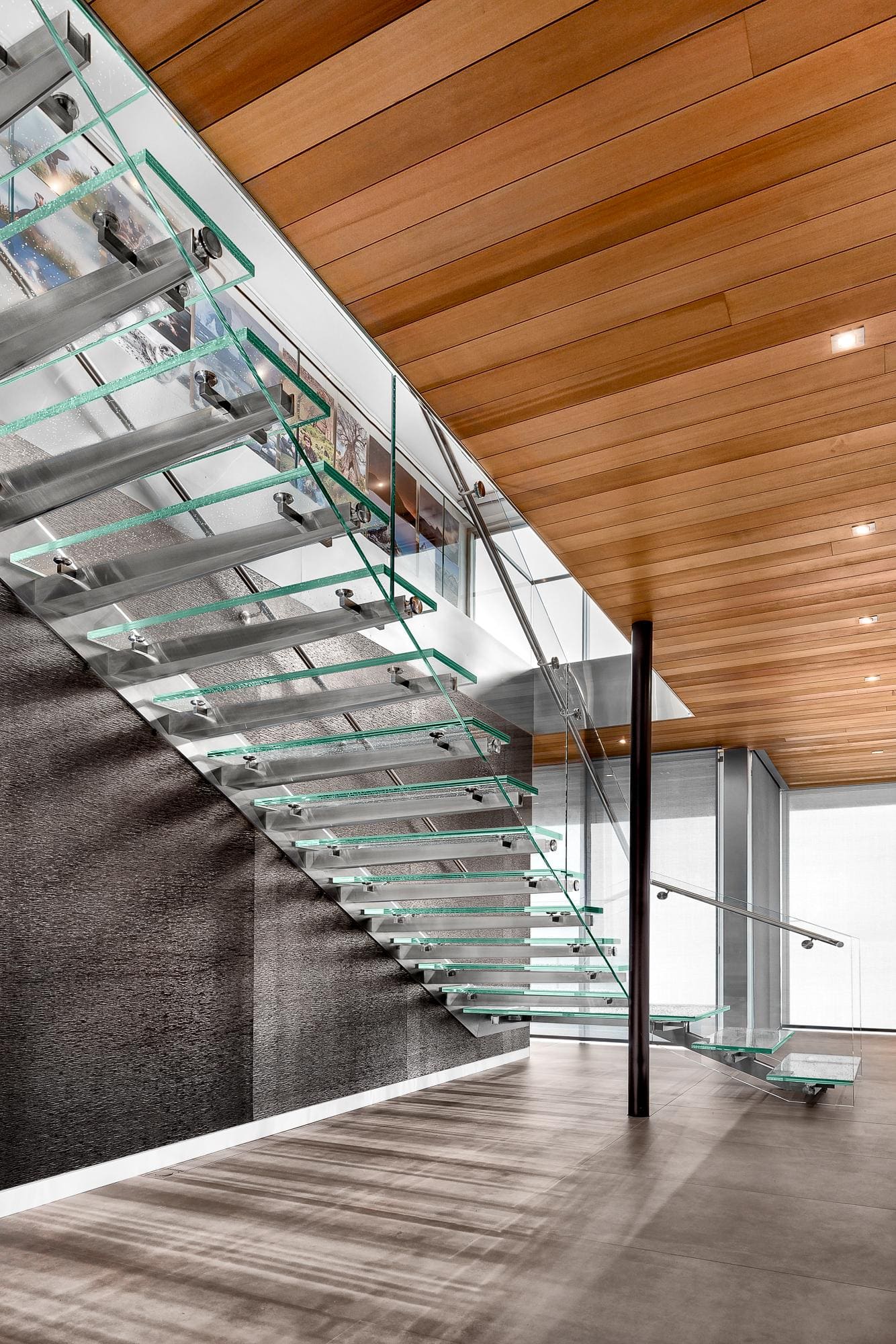 Minimalist still-life of a bowl of fruit displayed against a clear glass panel on a neutral background.