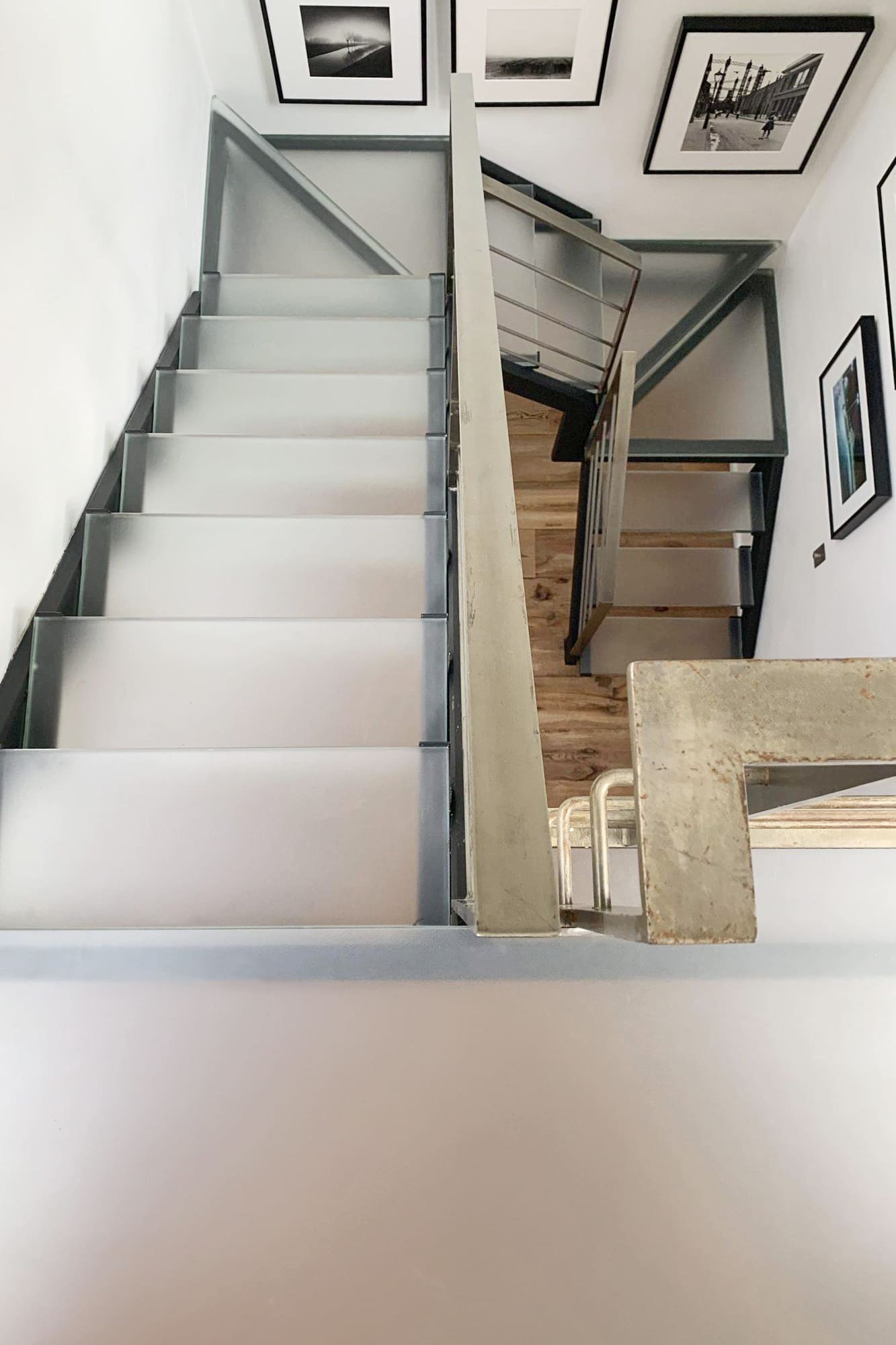 Straight glass staircase with frosted treads and metal framing in a minimalist residential interior.
