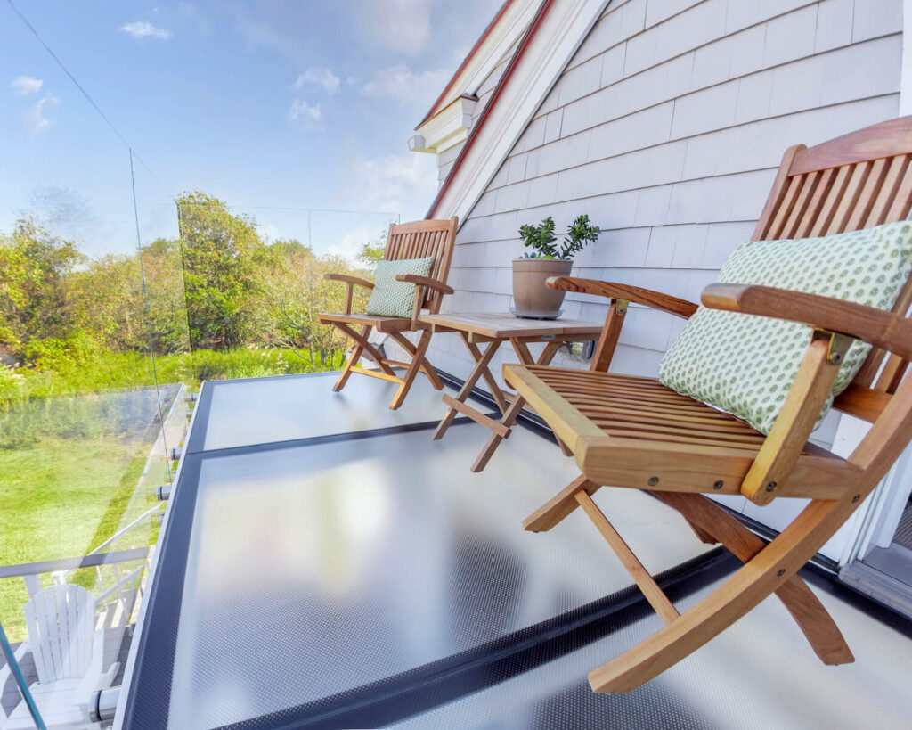 2 wooden chairs on glass balcony