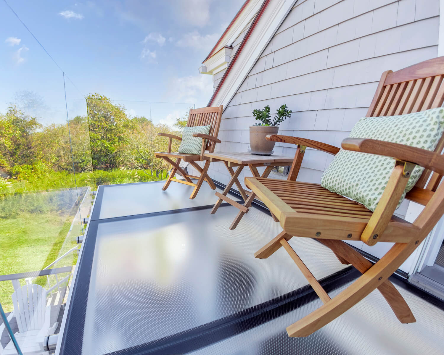 2 wooden chairs on glass balcony