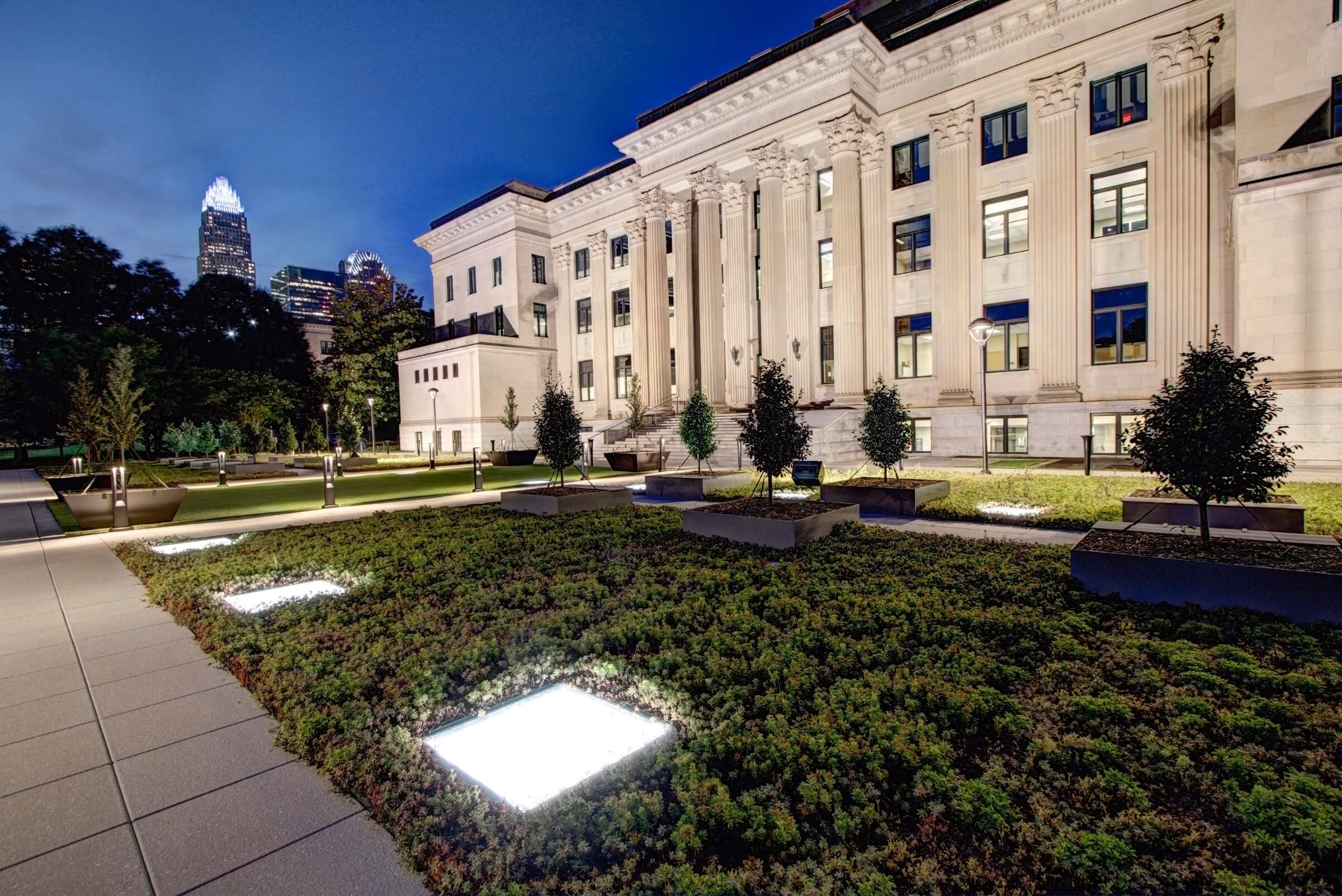 glass panels lit at night in front of large building