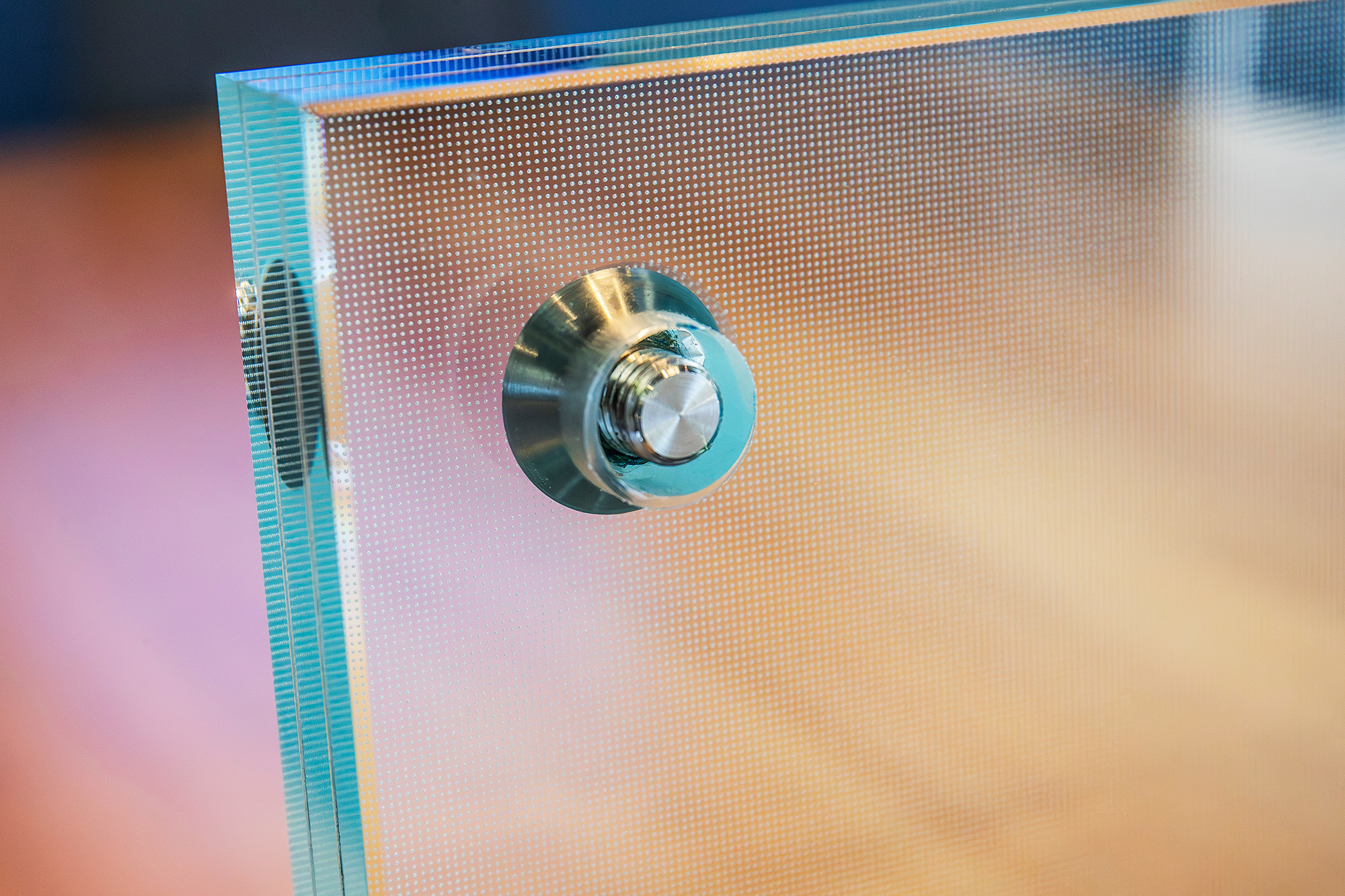 Close-up of a laminated textured glass stair tread with polished edges and a titanium embedded fastener.