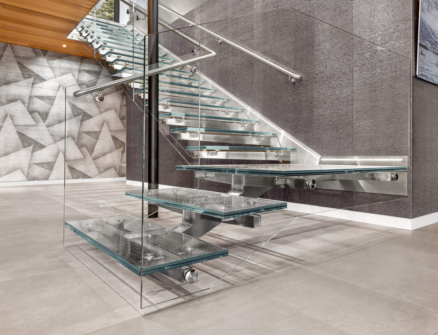 A glass staircase with a metal frame and handlebars.