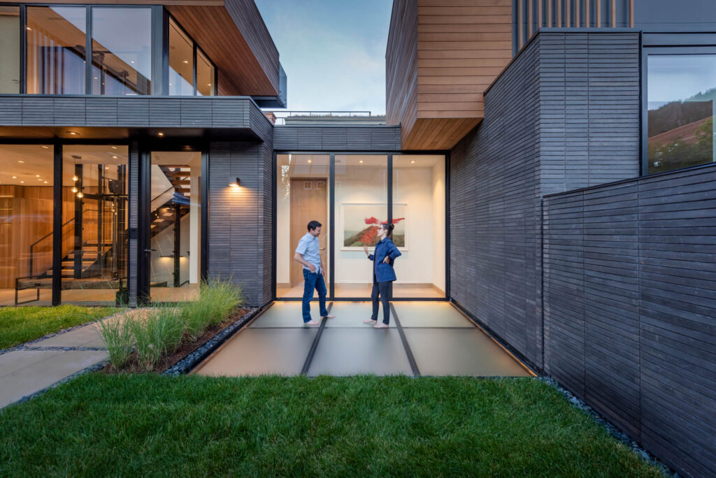 Contemporary Aspen residence at dusk with a flush SkyFloor Series 1000 walkable green roof skylight set into the lawn between the house wings